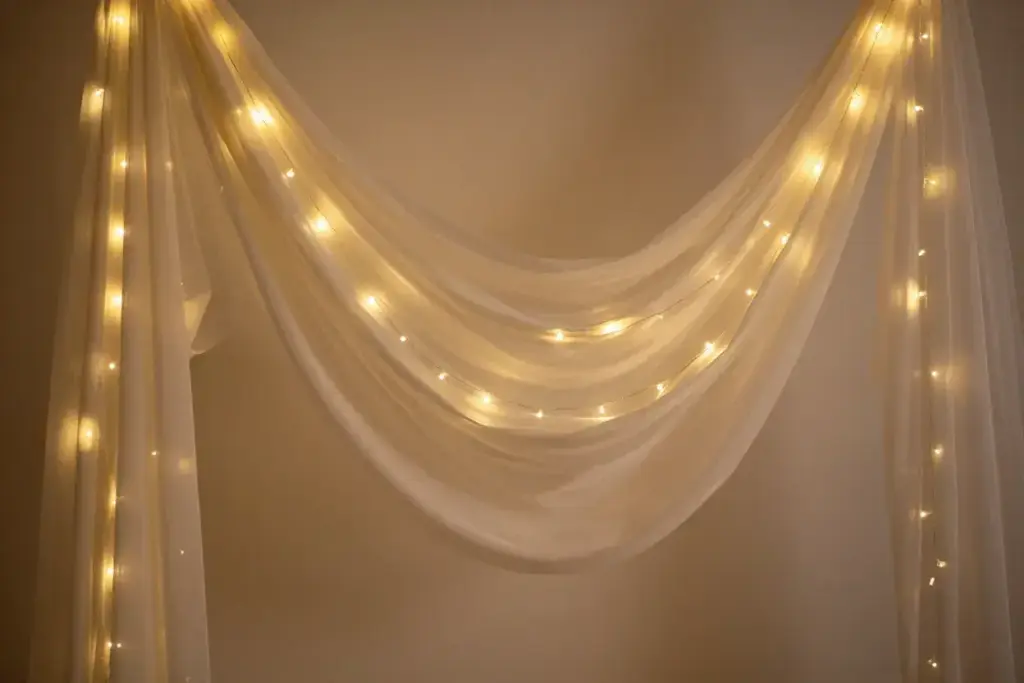 Sheer fabric drapes with fairy lights woven inside romantic glow