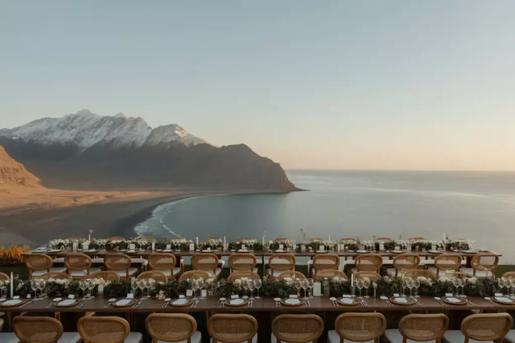 Wedding tables with low centerpieces facing mountain sunset view