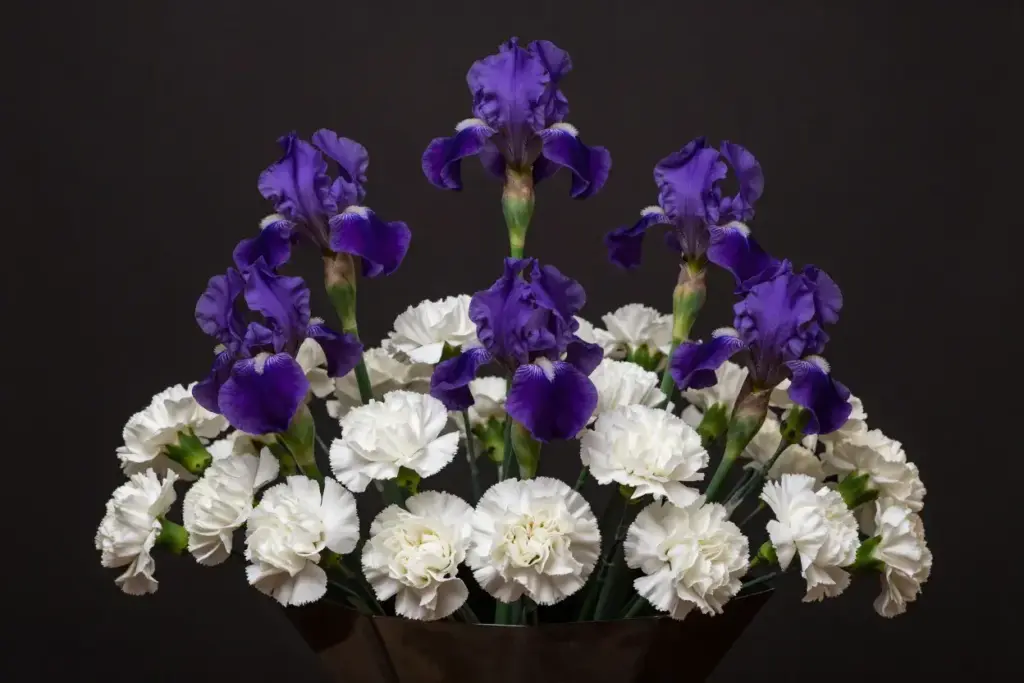 Purple irises white carnations geometric vase formal centerpiece bouquet